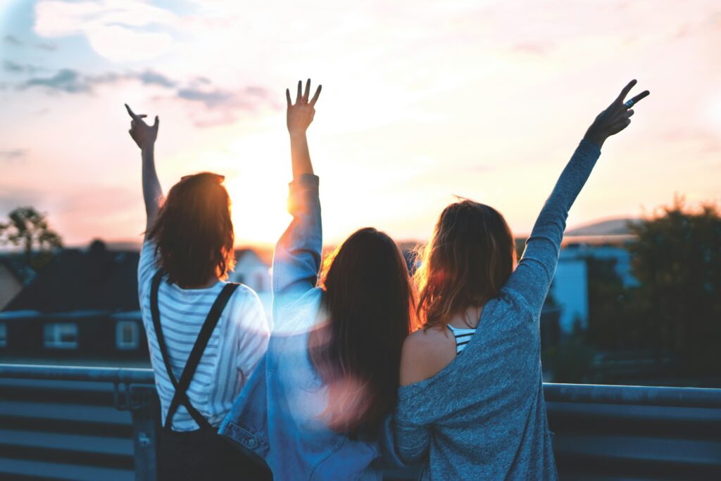 drei Frauen stehend jubelnd auf einem Balkon